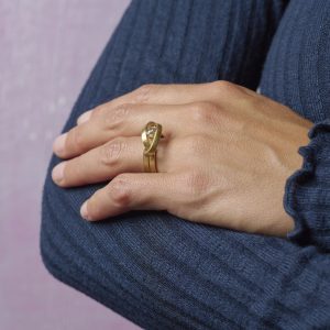 Zeitgenössischer Schmuck München Goldring geschwungen mit Diamant an Damenhand